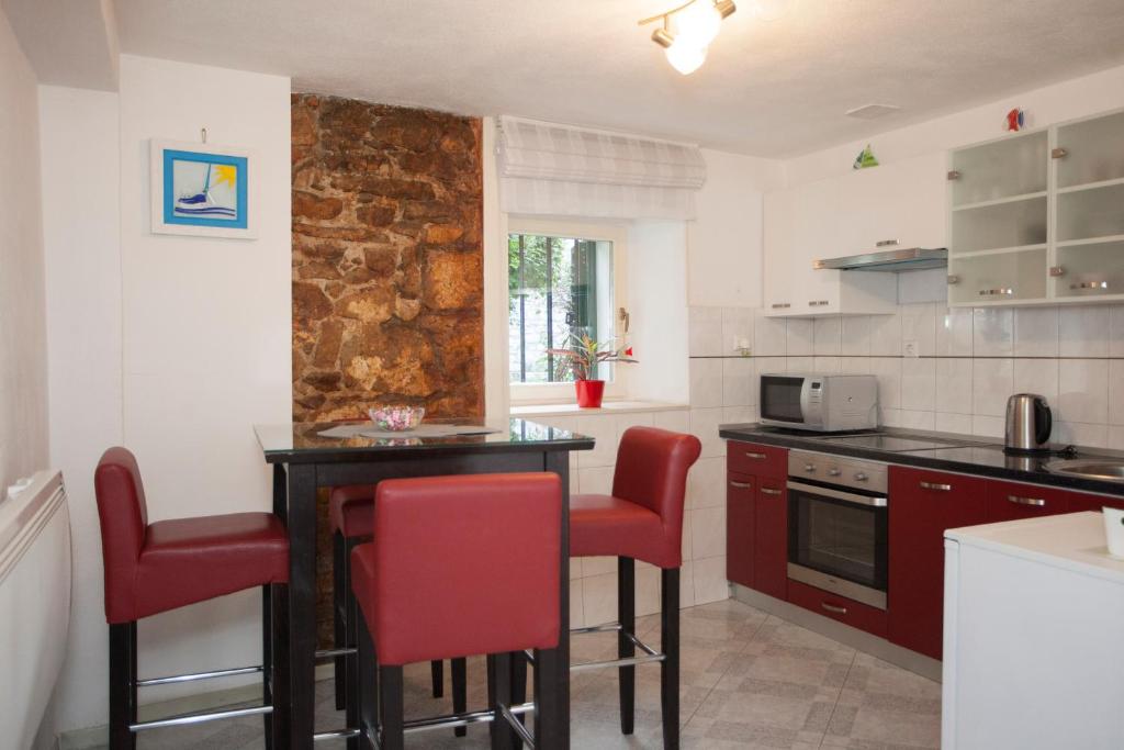 una cocina con mesa y sillas rojas. en Tarino Apartment, en Split