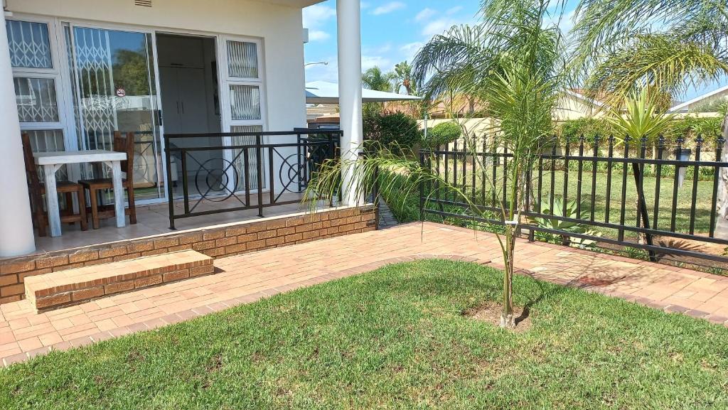a palm tree on a porch of a house at Come Home in Oudtshoorn Self-Catering Units in Oudtshoorn