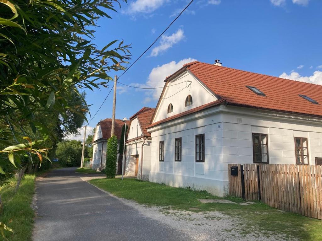 a white house with a red roof on a street at Klobucká manufaktura in Valašské Klobouky