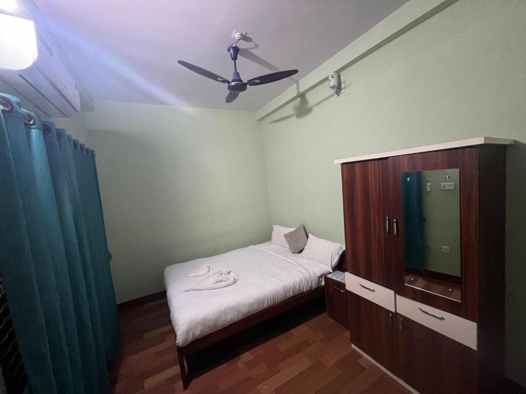 ein Schlafzimmer mit Bett und Deckenventilator in der Unterkunft hotel tuki in Kawasoti