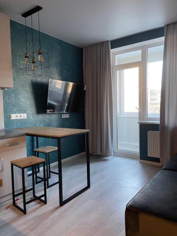 a living room with a table and two stools at Sky City room in Odesa