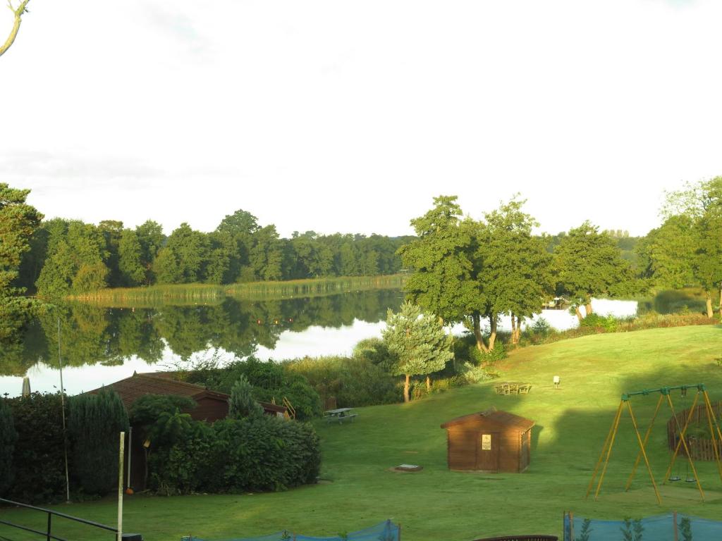 widok na park z placem zabaw i jeziorem w obiekcie Annexe at Gosfield Lake w mieście Gosfield