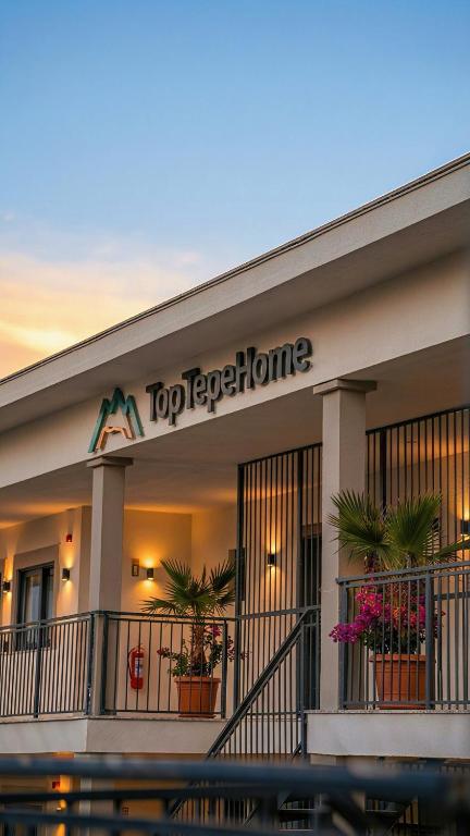a top predator home building with potted plants in front at TopTepeHome in Tire