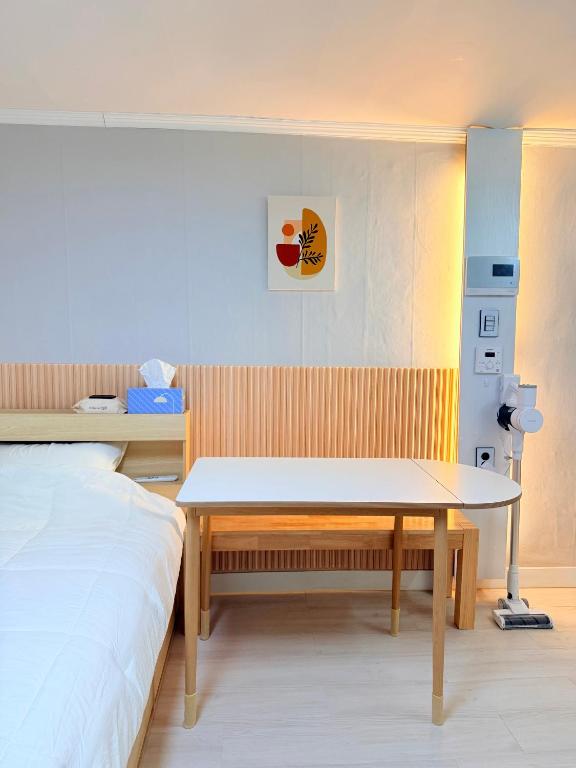a bedroom with a bed and a table in it at Cozy Studio Cheonho in Seoul