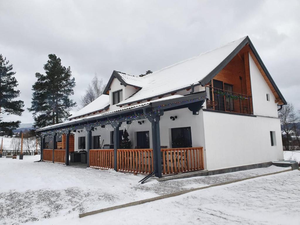 ein Haus mit Schnee darauf in der Unterkunft Vama Buzaului Hillside Barn - camere la munte in Vama Buzăului