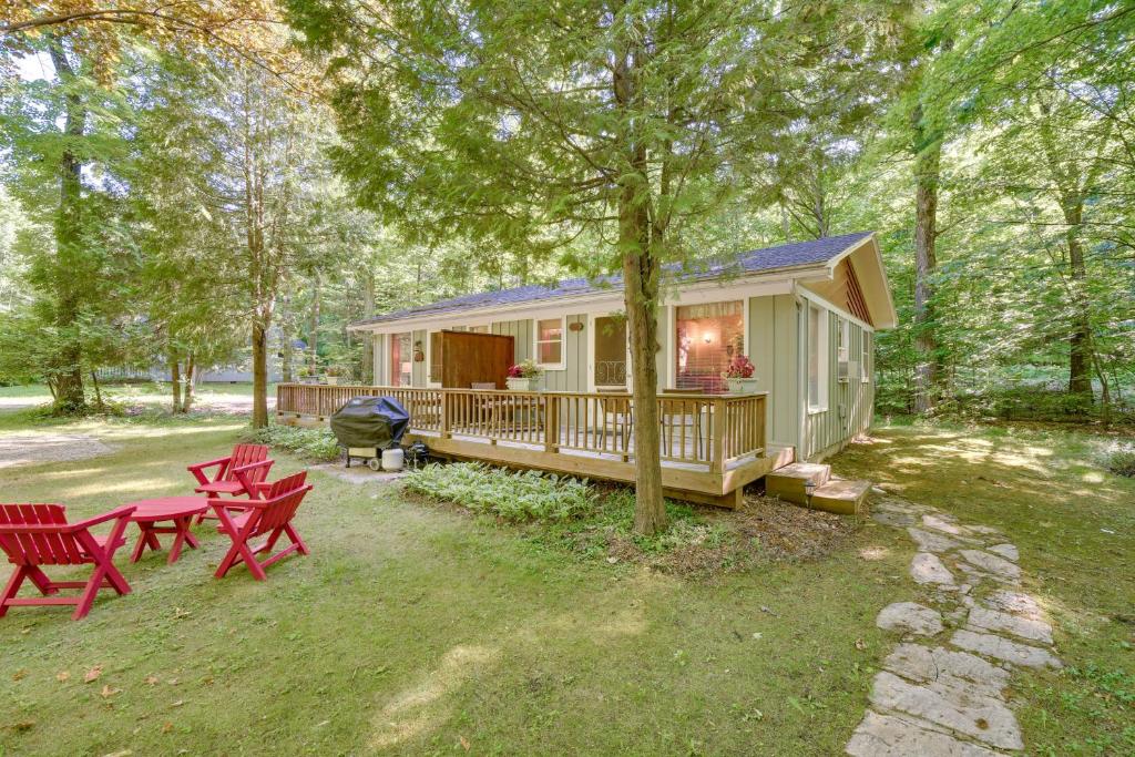 a tiny house in the woods with red picnic tables at 'Pine Cottage' Duplex w/ Deck: Walk to State Park! in Ephraim