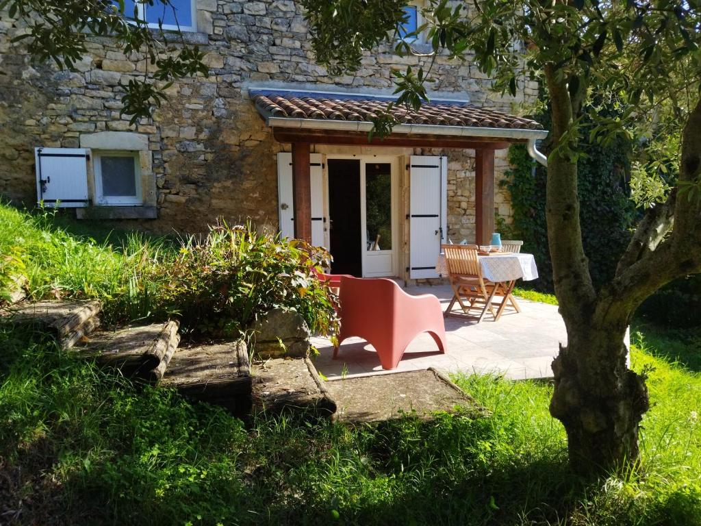 a house with a table and a chair in a yard at Gîte Côté Sud in Vagnas
