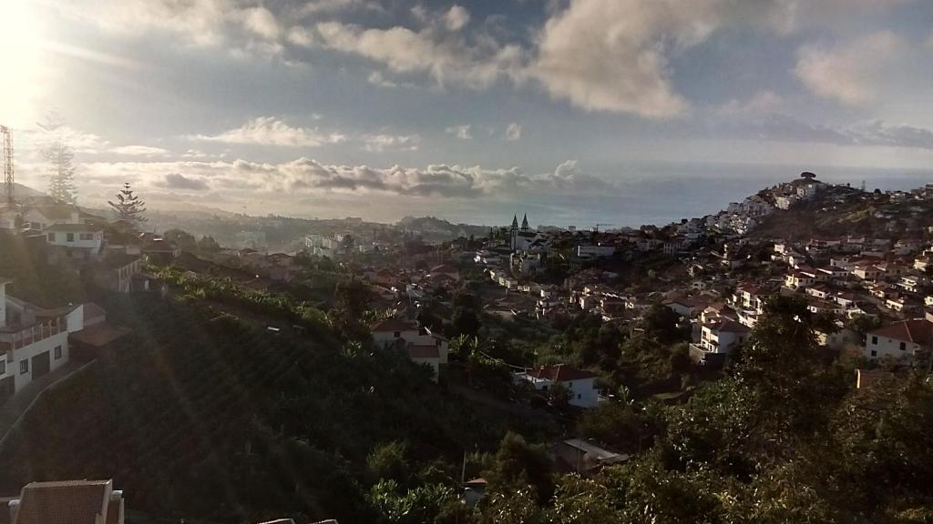 einen Blick auf eine Stadt mit der Sonne am Himmel in der Unterkunft Vista Funchal in Funchal