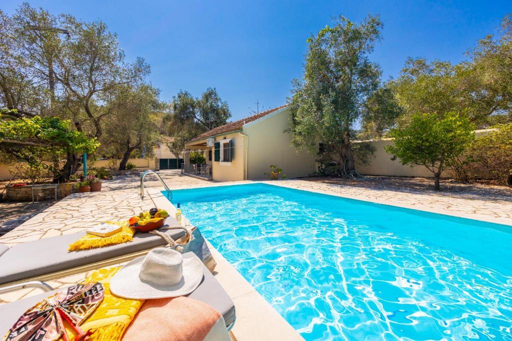 a swimming pool in front of a house at Villa Old Vineyard in Kontogiannátika