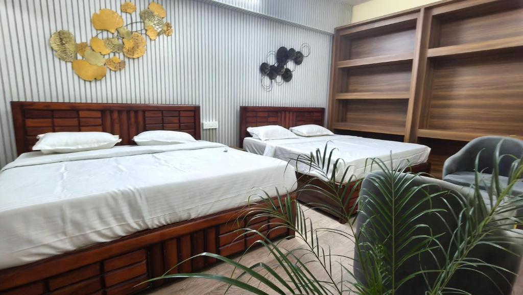 two beds in a room with plants at Amara Homestays in Prayagraj