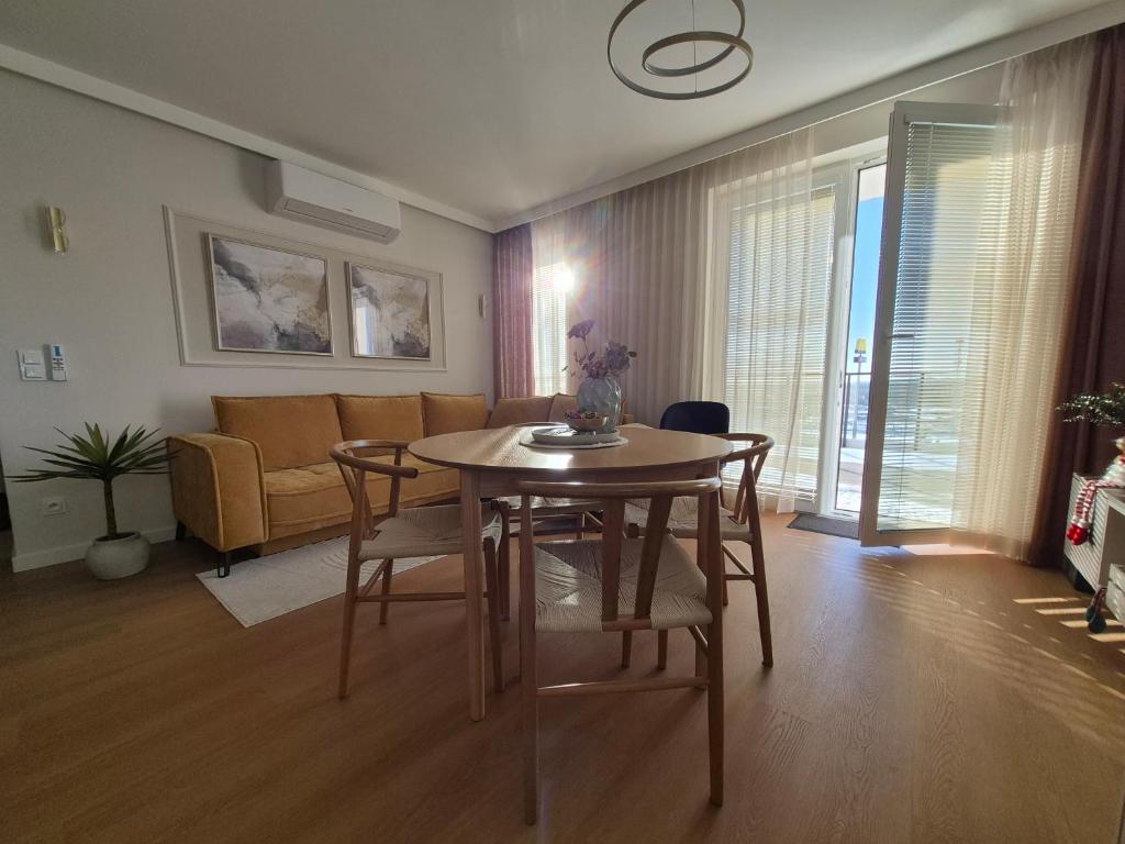 a living room with a table and chairs and a couch at Apartamenty Zajazd u Marcela in Tuchola