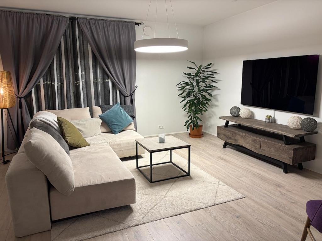 a living room with a couch and a flat screen tv at Cozy ocean front apartment in Reykjavík