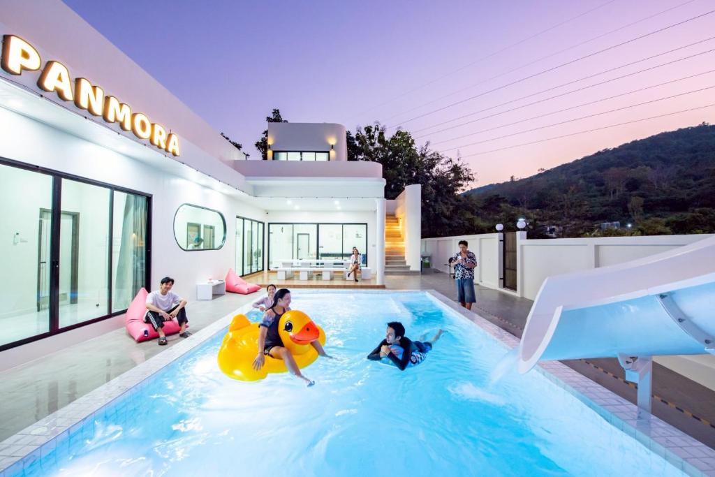 a family playing in a swimming pool in a house at Panmora Poolvilla Sattahip in Ban Tao Than