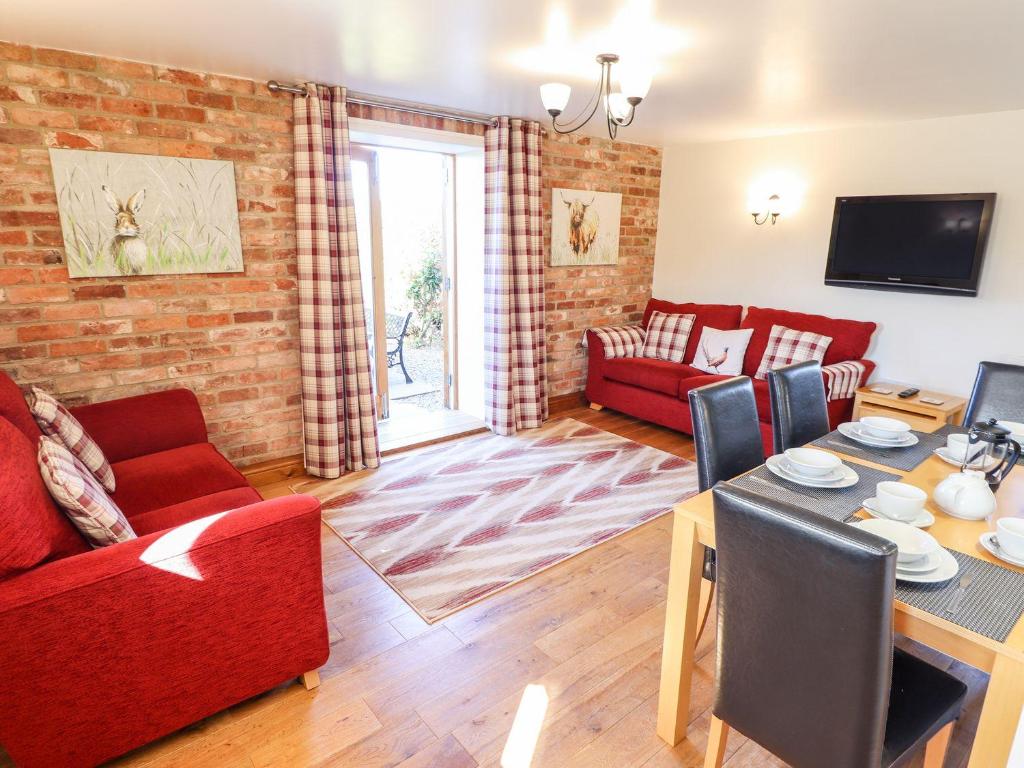 a living room with a red couch and a table at The Mill House in Louth