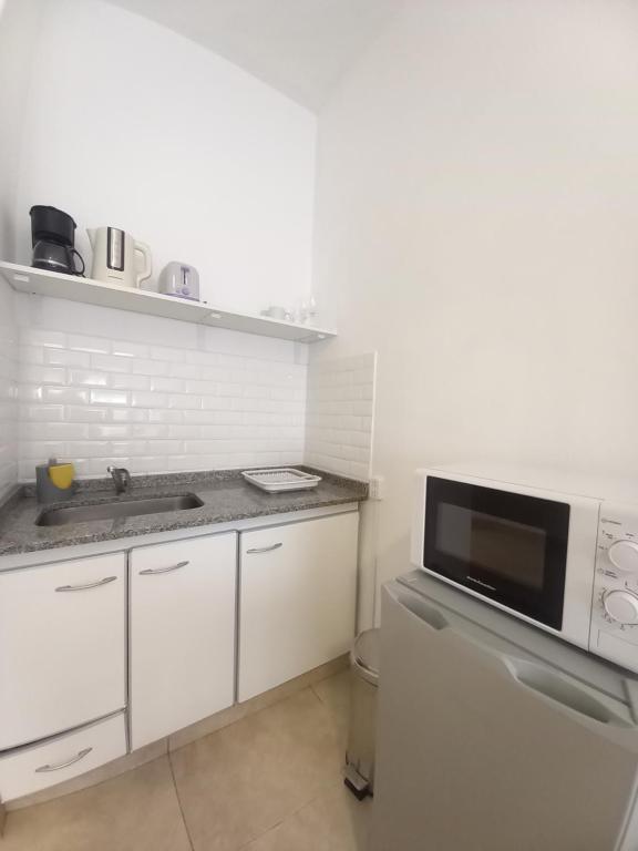a kitchen with white cabinets and a microwave at Osiris Plaza in Buenos Aires