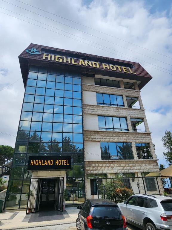 a highland hotel with cars parked in front of it at HighLand Hotel in Aley
