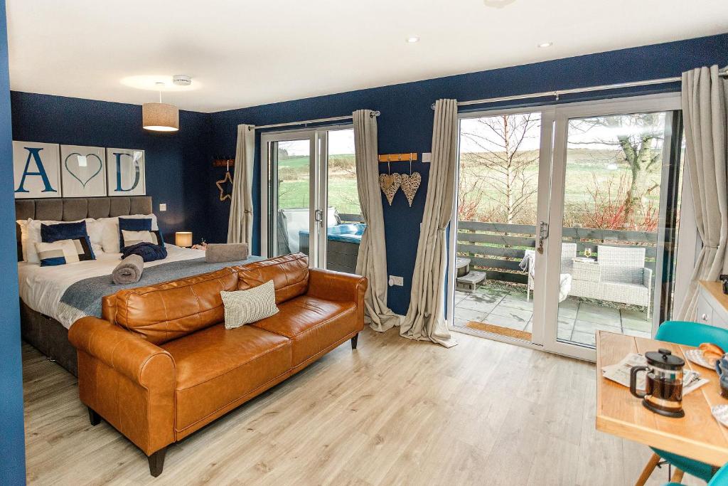 a bedroom with a bed and a leather couch at Annabelle's Den in Gatehouse of Fleet