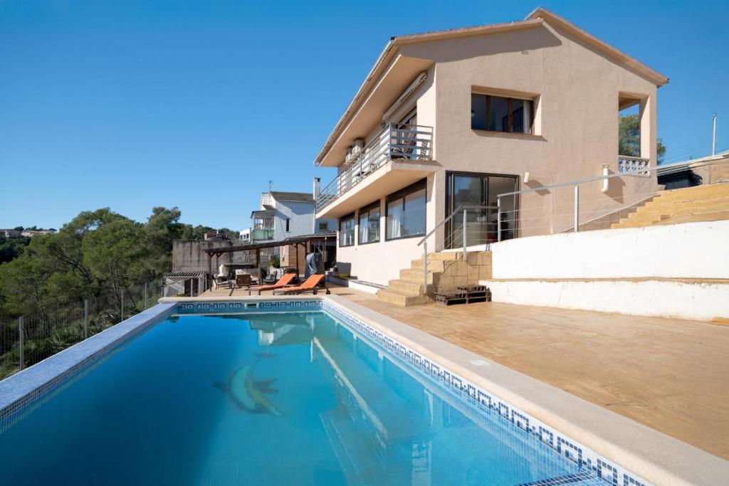a house with a swimming pool in front of a house at Mima House with Pool in Canyelles