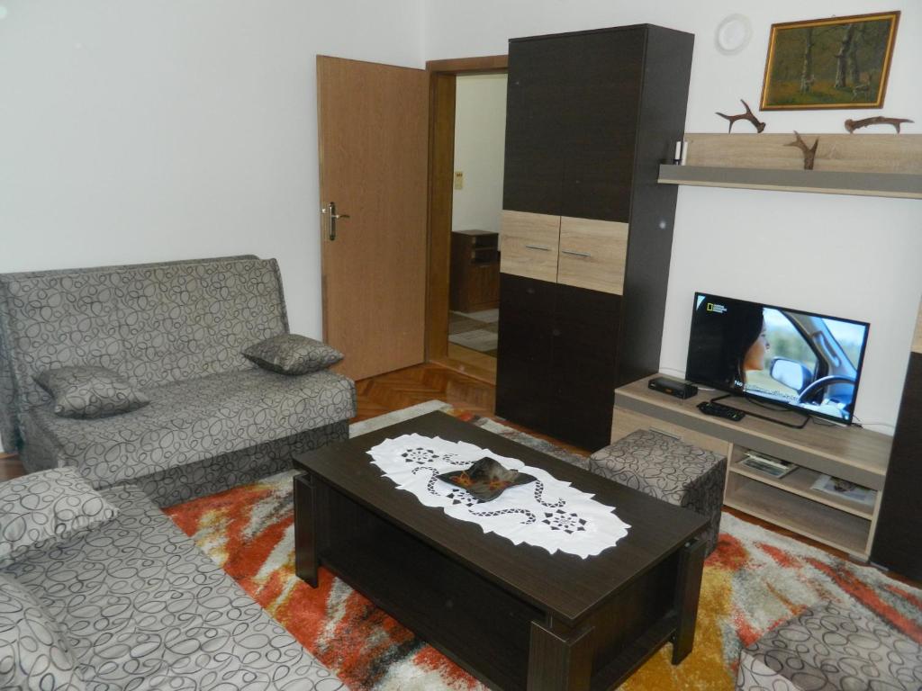 a living room with a couch and a coffee table at Apartman Sutjeska in Tjentište