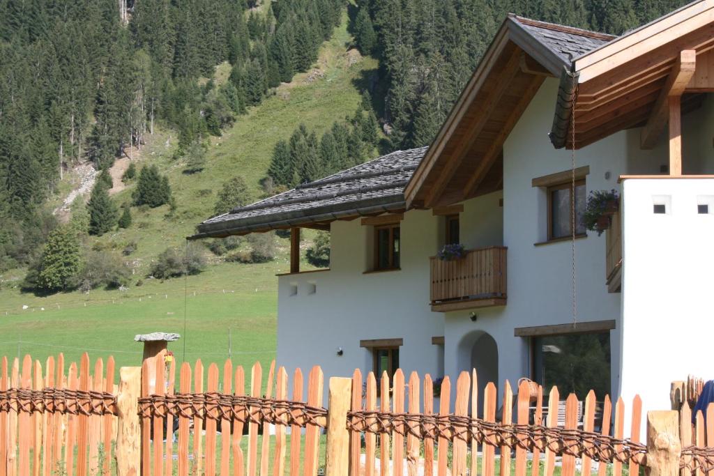 a fence in front of a house with a mountain at Ferienhaus "Larch Soge" in Racines