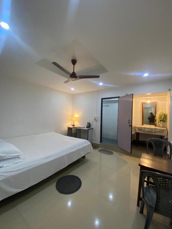 a bedroom with a bed and a ceiling fan at Nagaon Homestay in Nowgong