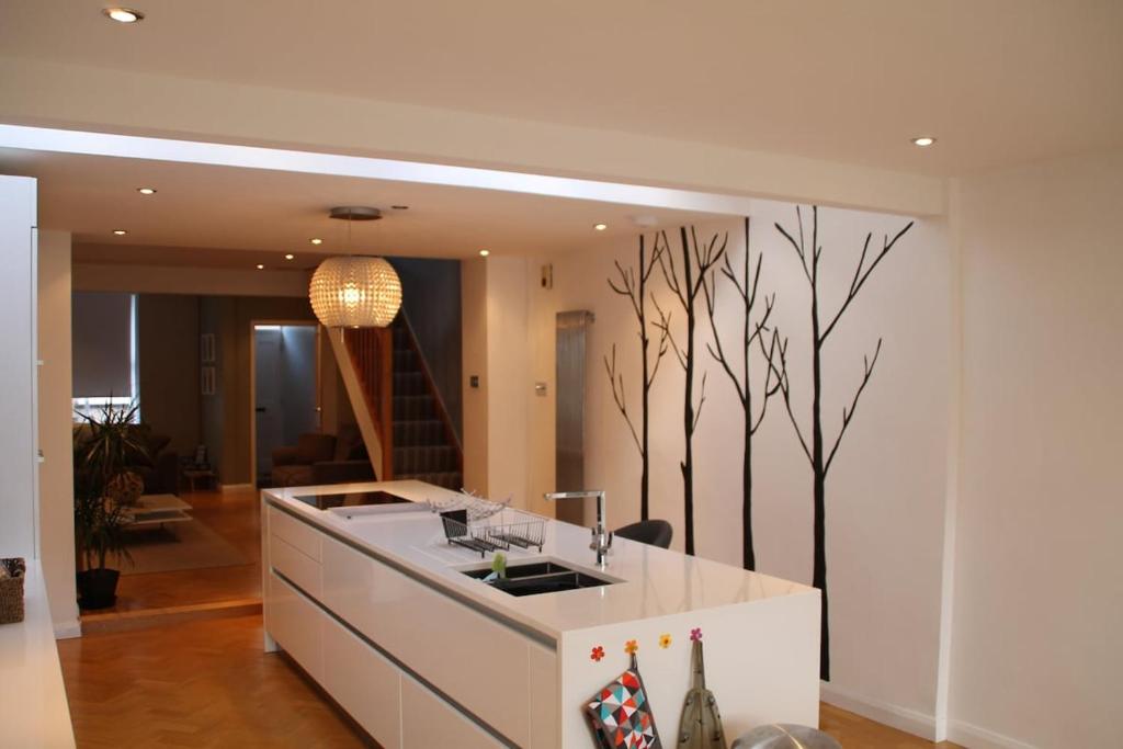 a kitchen with a white counter and trees on the wall at Snowdon View in Llanberis