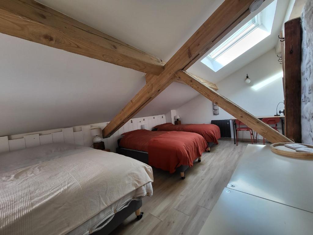 una camera da letto mansardata con due letti e una finestra di Naëlo Chartreuse a Biviers