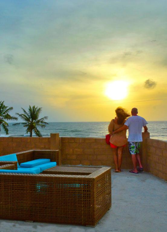 a man and woman standing on a wall looking at the ocean at Ayurvedic Beach Resort in Negombo