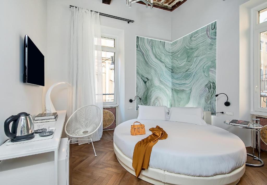 Biała sypialnia z białym łóżkiem i zieloną i białą ścianą w obiekcie Boutique Centrale Palace Hotel w Rzymie