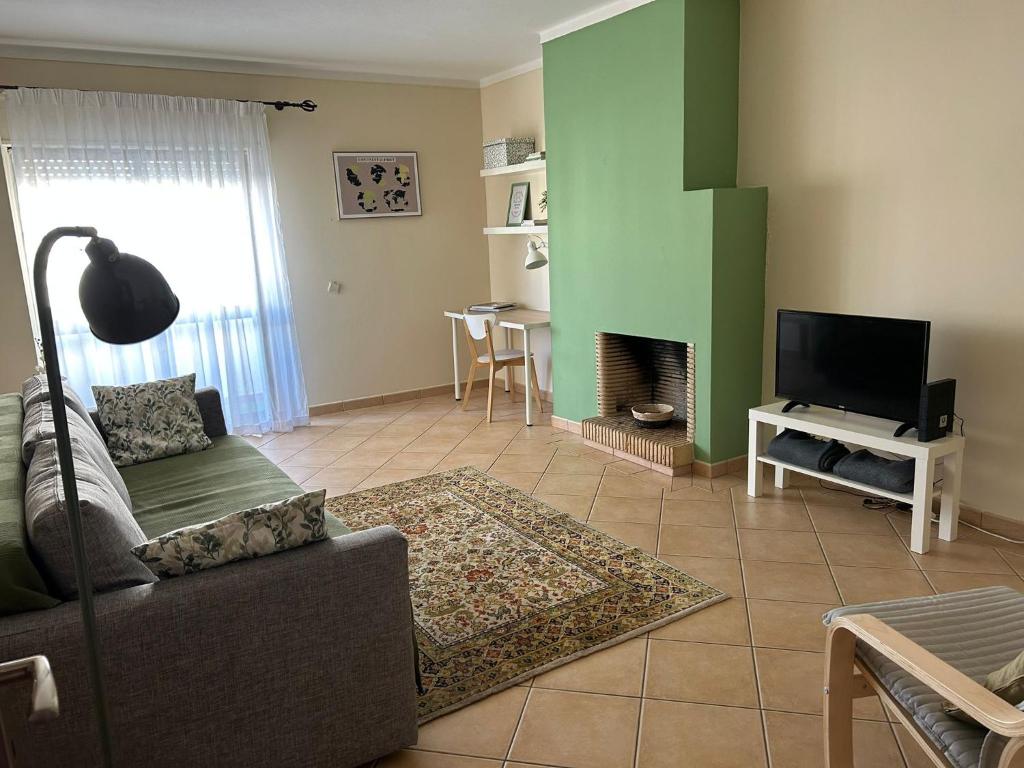 a living room with a couch and a television at cosy2bedroomapartment in Loulé
