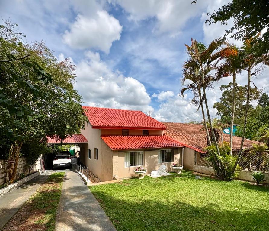 a house with a red roof and a driveway at Chácara do Paulinho in São Roque
