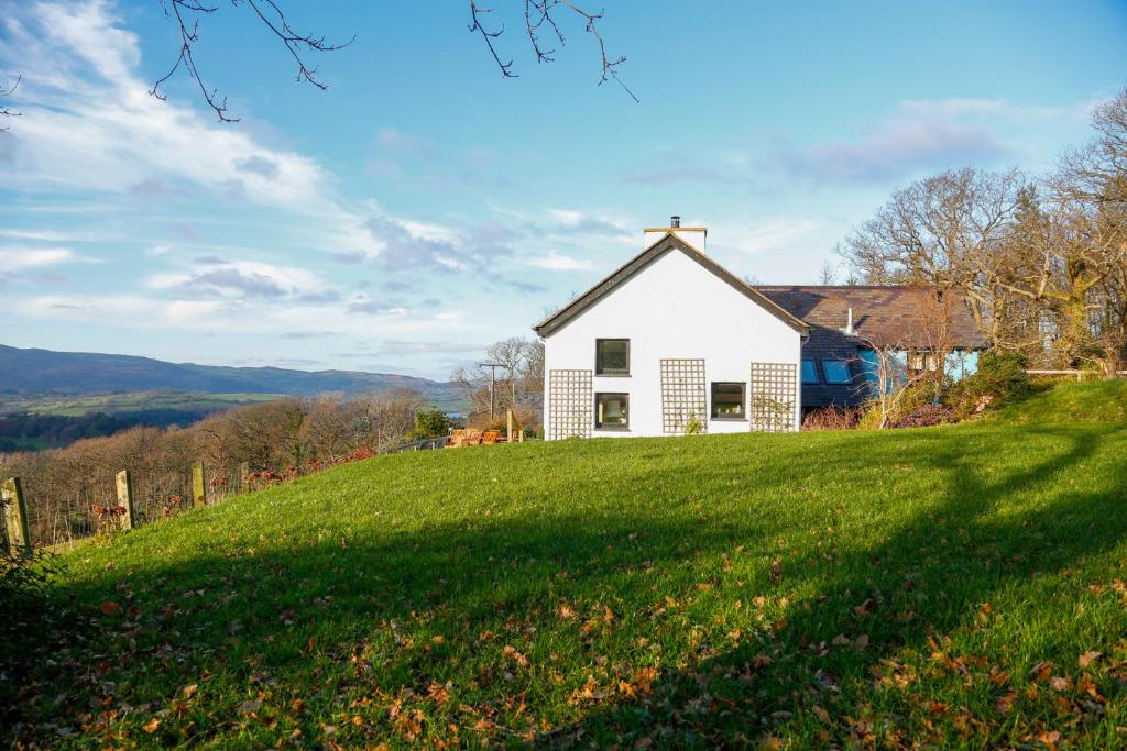 a white church on a hill with a green field at Ty Uchaf in Colwyn Bay
