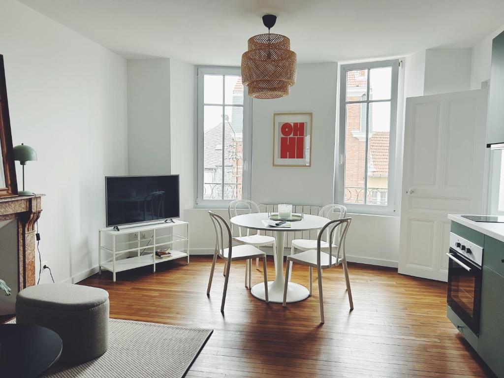 a kitchen and dining room with a table and chairs at Suite Jaurès in Rethel