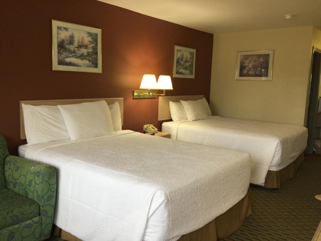 a hotel room with two beds and a chair at Americas Best Value Inn Cabot in Cabot