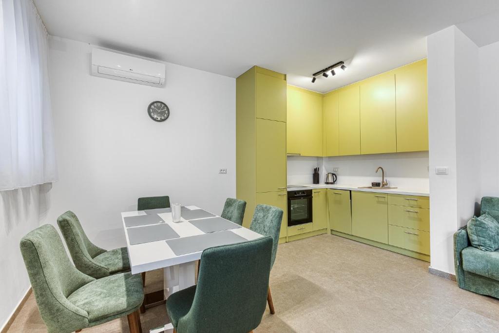 a kitchen and dining room with a table and chairs at Green Oasis Bečići in Boreti