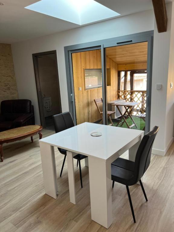 a white table and chairs in a living room at La Petite Ecole Chez Etche in Marciac