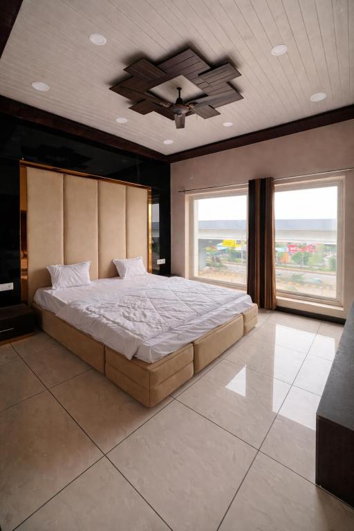 a bedroom with a large bed and a ceiling fan at The Golden Wings Hotel in Dewās