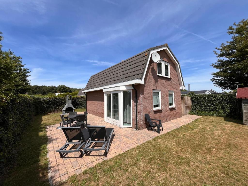 a small house with two chairs and a table at Bungalowverhuur 't Lappennest in Noordwijk