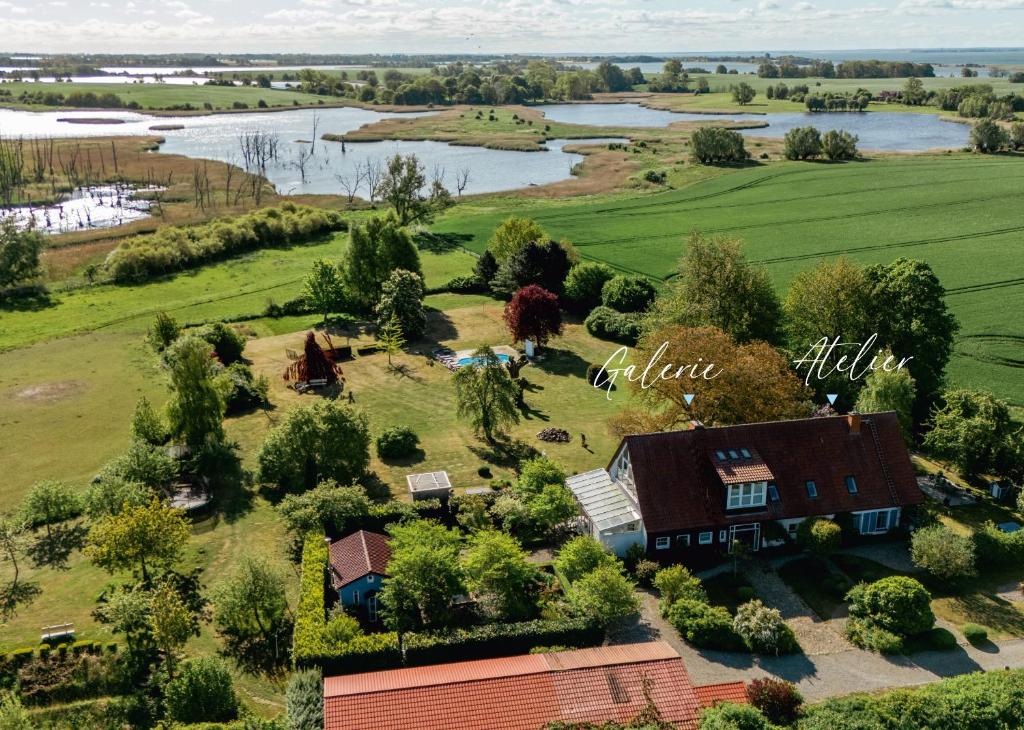 an aerial view of a farm with a house and a river at Landhaus einer Malerin in Poseritz