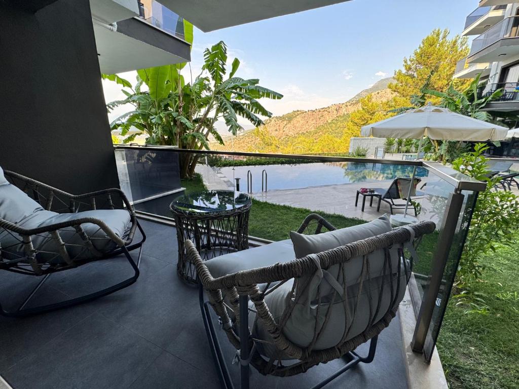 a balcony with chairs and a view of the water at Stylish Lounge Apartment with Pool & Views in Fethiye