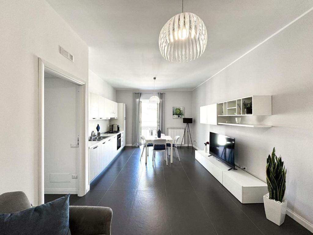 a living room with a couch and a tv and a kitchen at The Superhost - Duomo Apt in Crotone