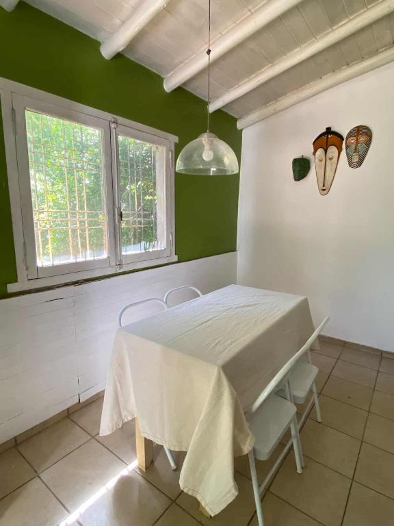 a dining room with a table and chairs and a window at Casa con quincho en el Volcán in El Volcán