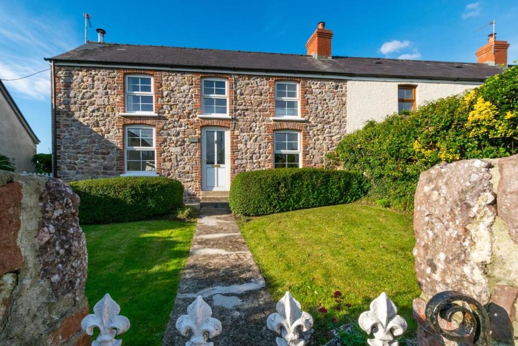 an old stone house with a garden in front of it at 3 Bed in Gower oc-hh150 in Llangennith