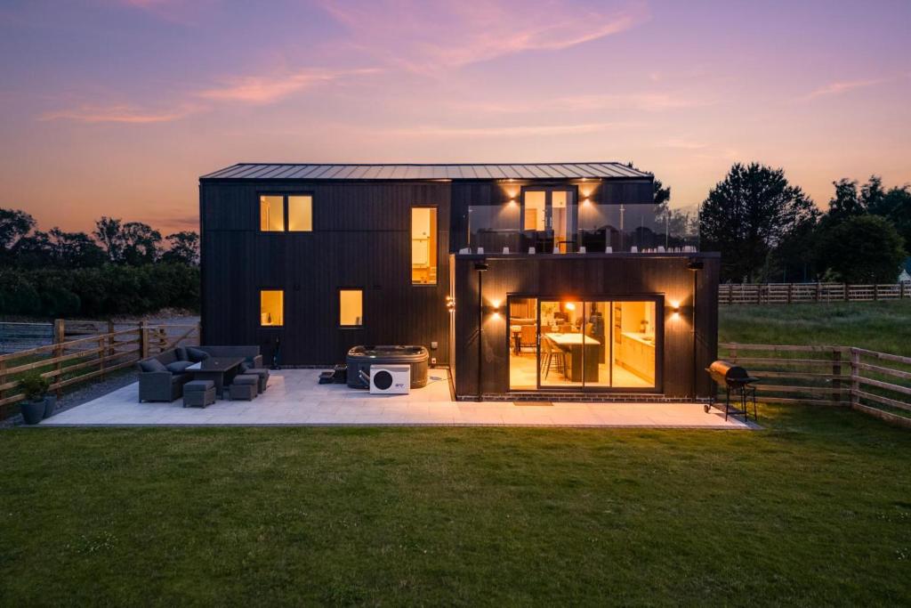 a small black house with a sunset in the background at 4 Bed in Crosby oc-b31135 in Northallerton