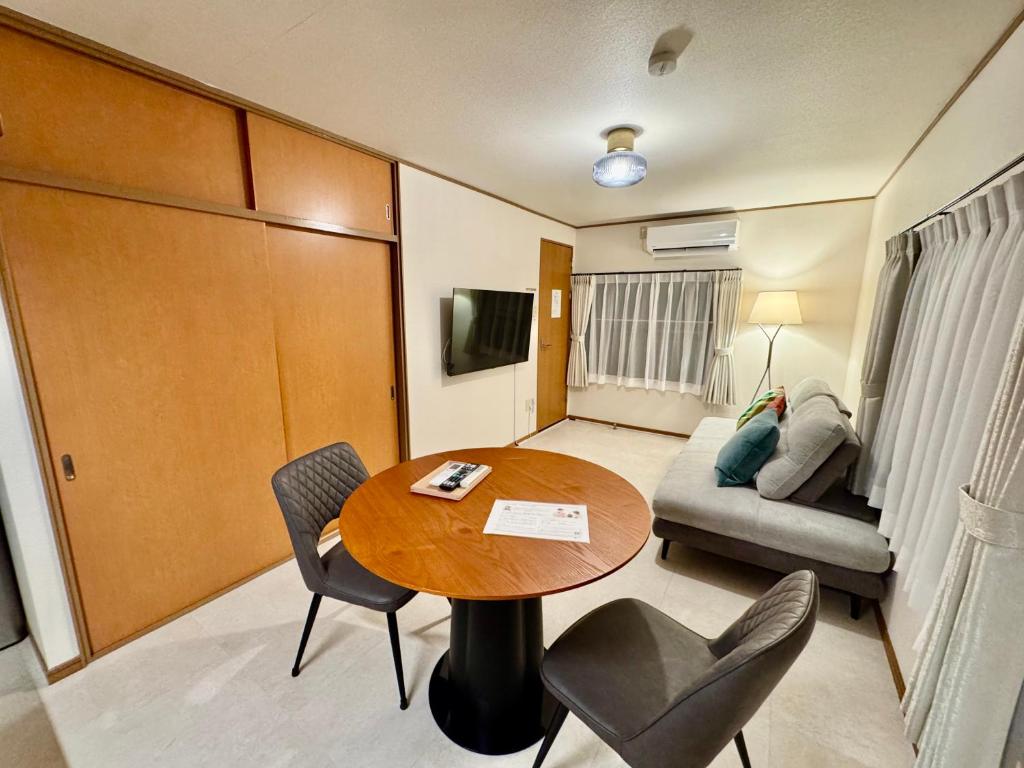 a living room with a table and chairs and a couch at VillaMonica Riverside in Nagoya