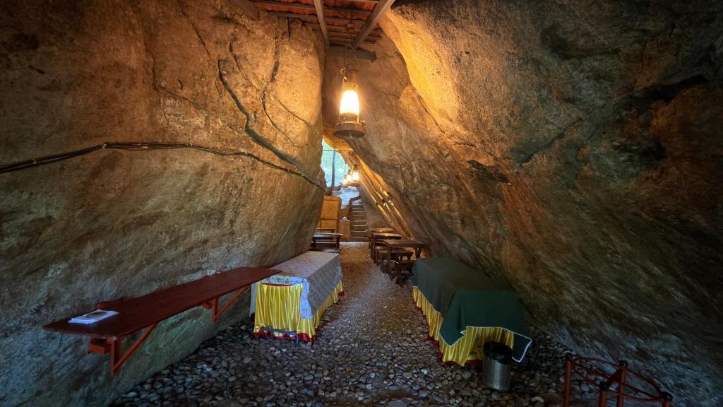 a tunnel with benches and tables in a cave at Qatsyir Horizon in Varagampadi