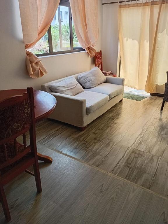 a living room with a couch and a wooden floor at Quiet corner ideal for holidays in Centre de Flacq