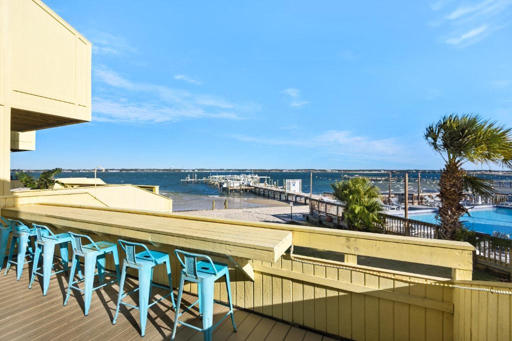 a row of blue stools on a balcony overlooking a beach at Buena Vida 23 in Navarre