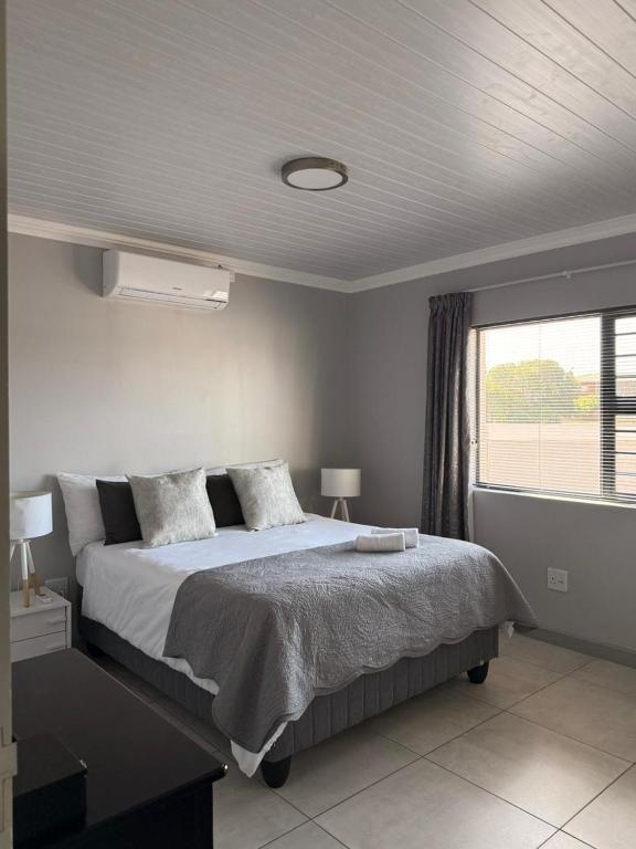 a bedroom with a large bed and a window at 17 On Sleigh in Langebaan