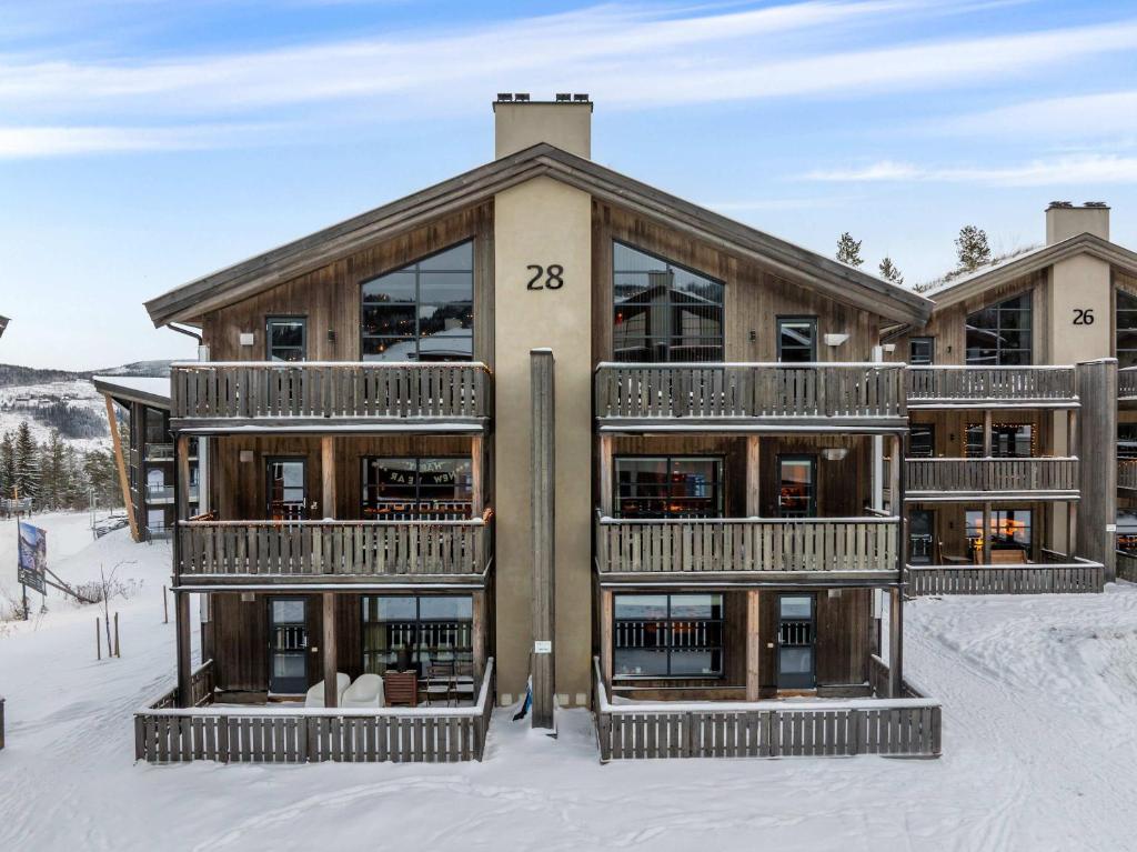 a house in the snow with the number at TT28- Ski-in out apartment in Trysil turistcenter with sauna in Trysil